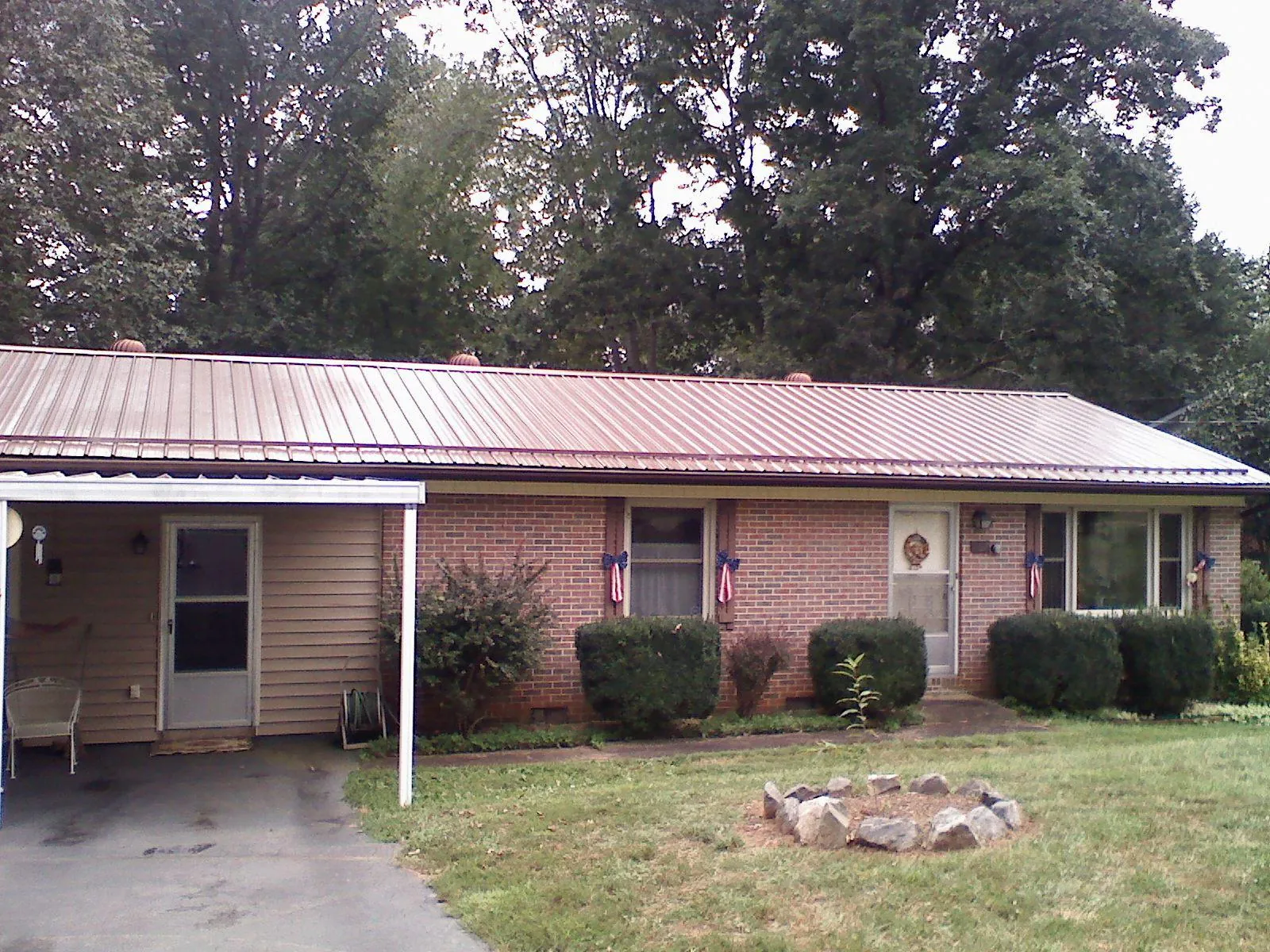 Bronze metal roof and carport on a brick ranch home — Roof Repair work by our crew in Lilly